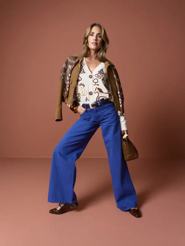 Tone mønstret strikkejakke, brun skinnjakke og sjal, jeans, belte, veske og ballerina i dyreprint.
