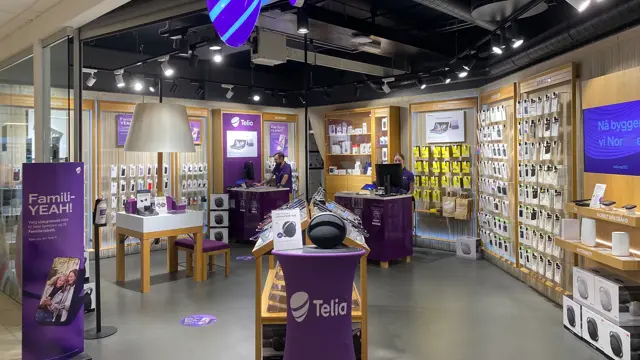 Innendørs butikk med lilla lys og skilter og reoler