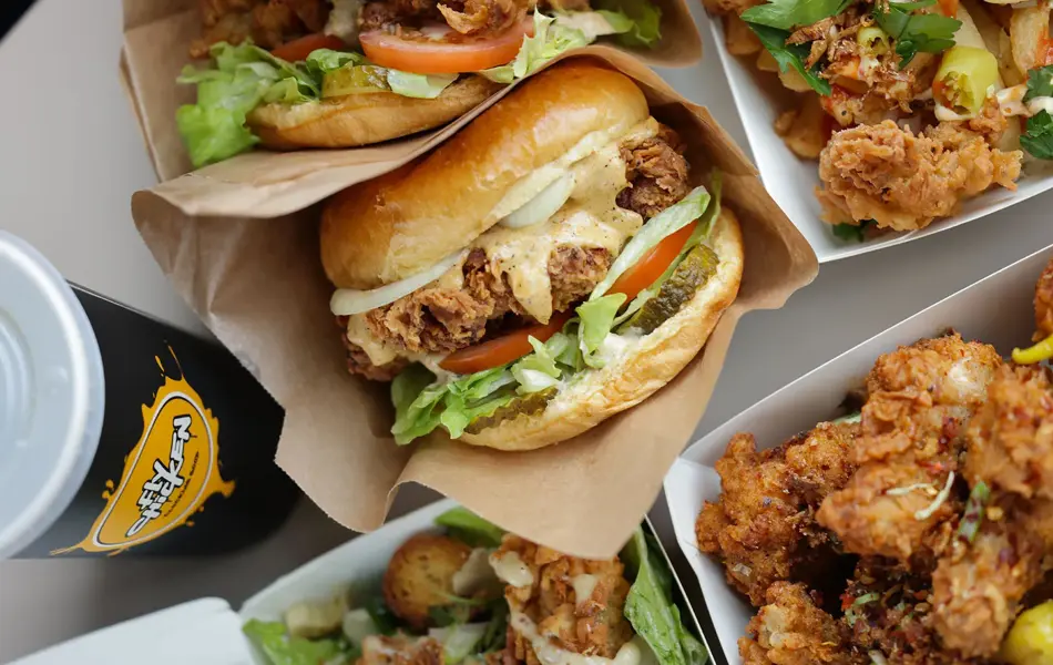 Burger med fried chucken og bokser med fried chicken