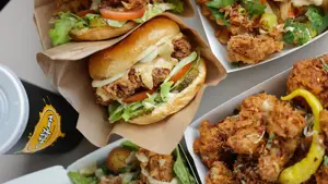 Burger med fried chucken og bokser med fried chicken