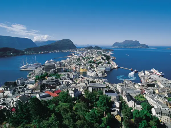 Utsikt over hele Ålesund by med fjord og fjell i bakgrunnen.