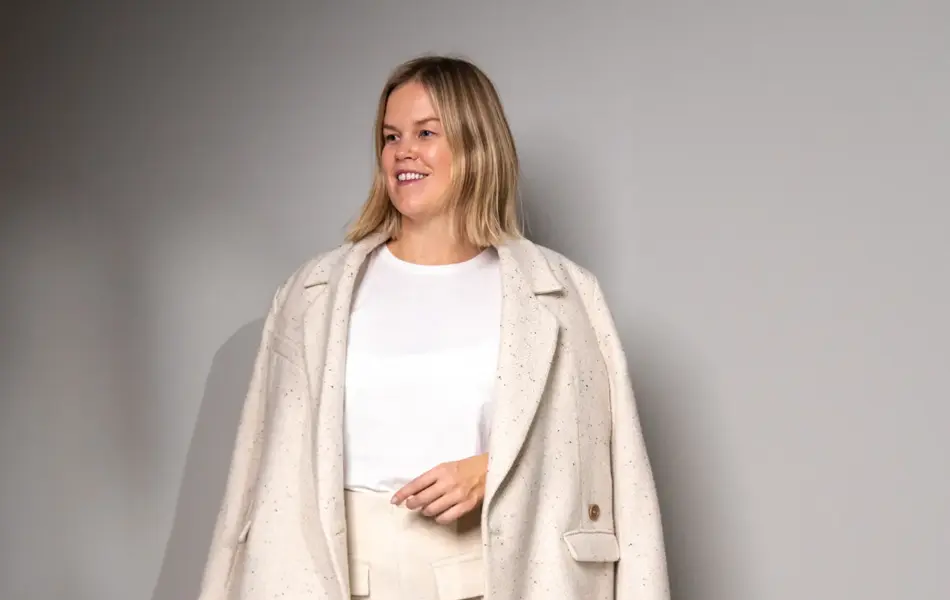 Damemodell i hvitt skjørt, bomullstopp og blazer