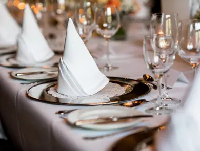 Bordsetting med hvit duk, hvite servietter og tomme vinglass