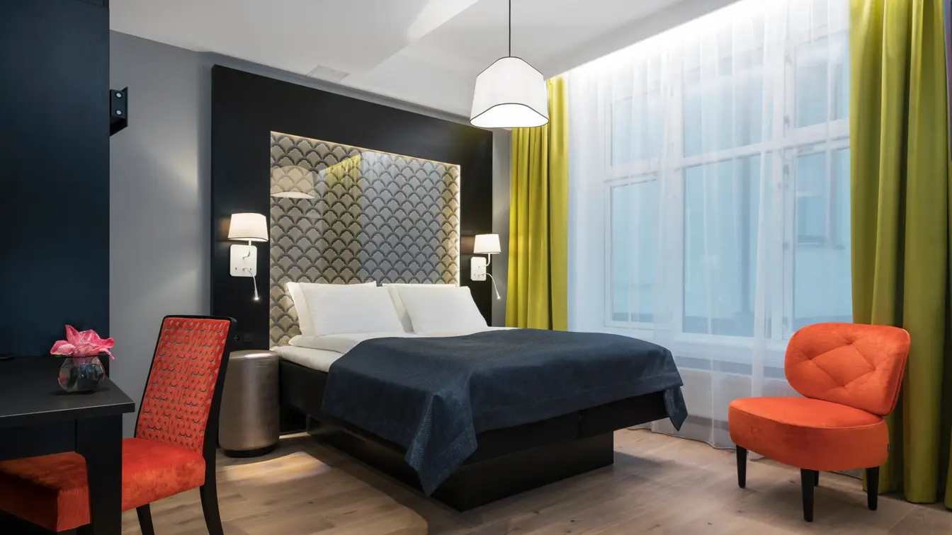 Dobbeltseng, skrivepult og sitteplass med mye gulvplasspå handikaprom på Thon Hotel Spectrum i Oslo sentrum