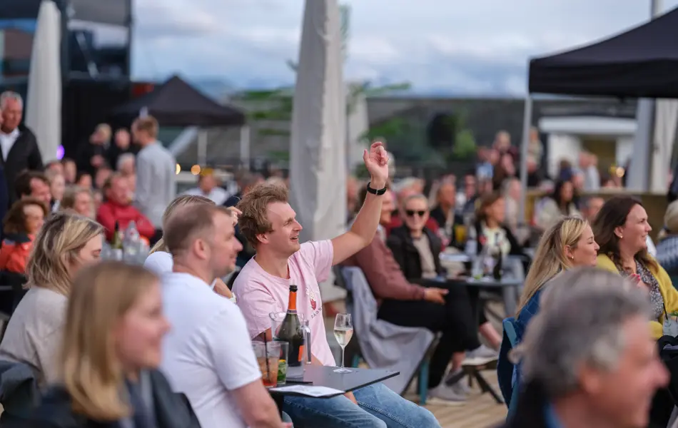 En gruppe mennesker som ser på en utekonsert