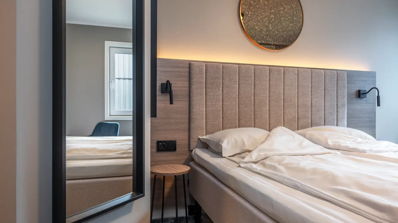 Dobbeltrom med queen seng, speil, sengegavl og nattbordslamper