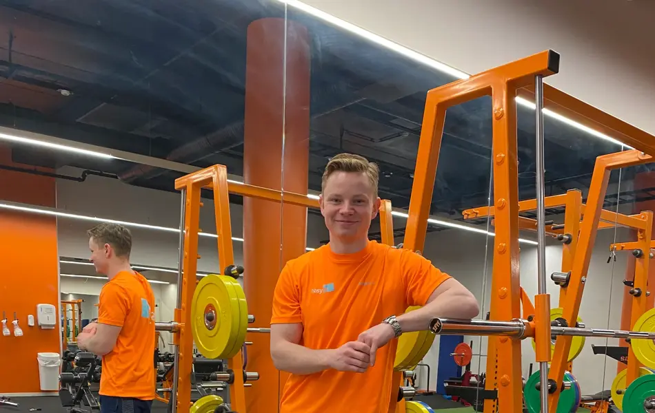 Håkon fra treningssenterte Easyfit lener seg på et treningsapparat