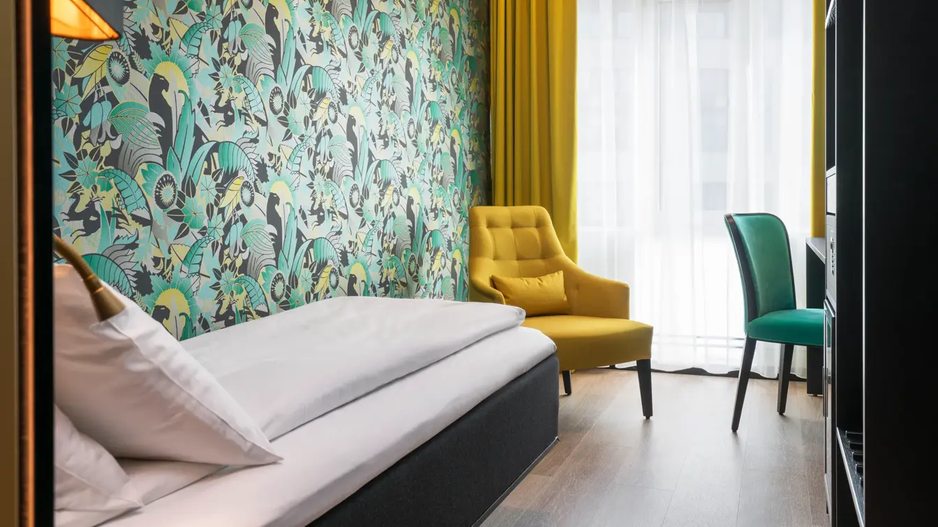 Enkeltrom med tapet, gardiner, lenestoler og seng