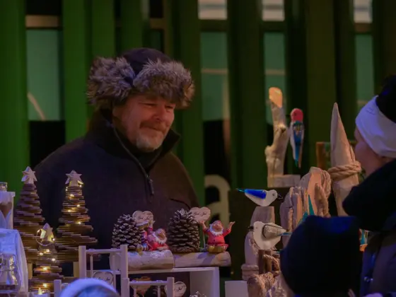 Helge som står på julemarked med kunder