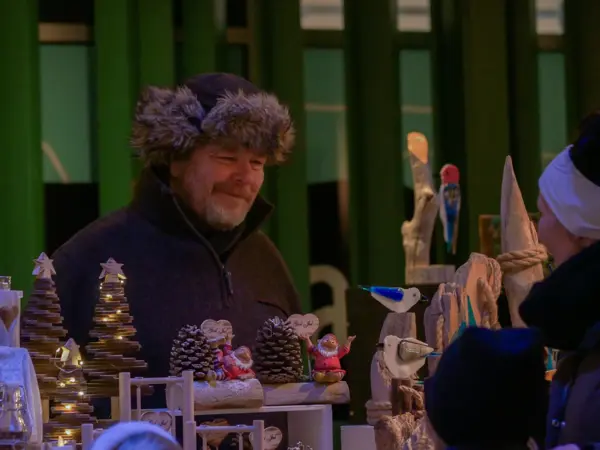 Helge som står på julemarked med kunder