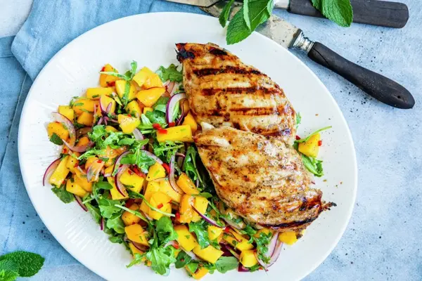 tallerken med grillet kyllingfilet og mangosalat