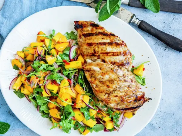 tallerken med grillet kyllingfilet og mangosalat