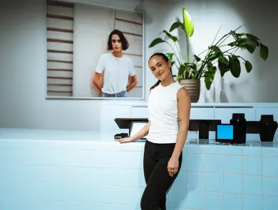 Dame som lener seg på en disk og ser rett i kamera