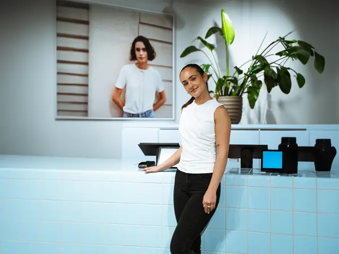 Dame som lener seg på en disk og ser rett i kamera