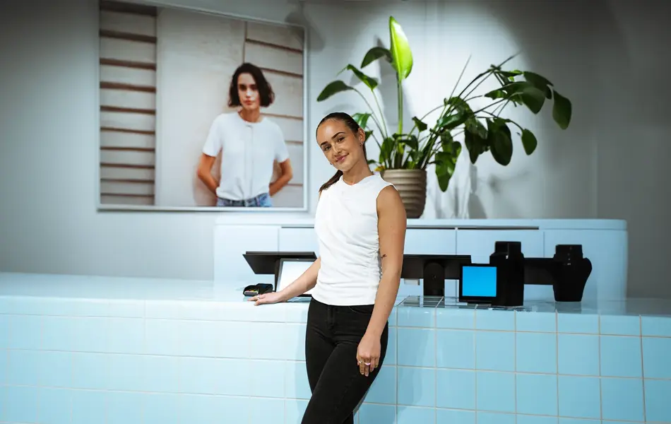 Dame som lener seg på en disk og ser rett i kamera