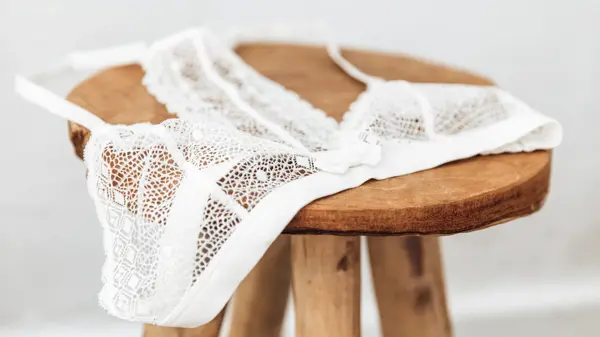 White delicate lace bra on a wood  stool