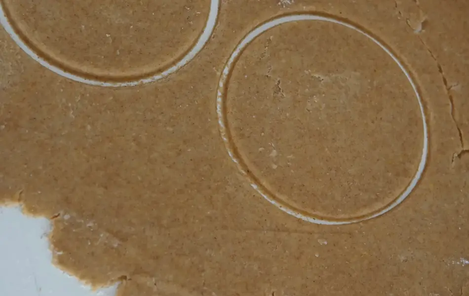 Bakebrett med utkjevelet deig og stukket ut to sirkler