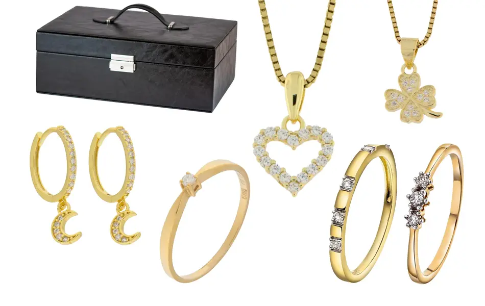 Sort smykkeskrin, kjed med hjerteanheng, kjede med firkløver-anheng, øredobber med stener, gullringer med stener.