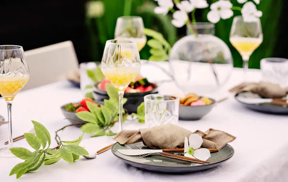Bord dekket mørkt service og høye glass på en hvit duk 