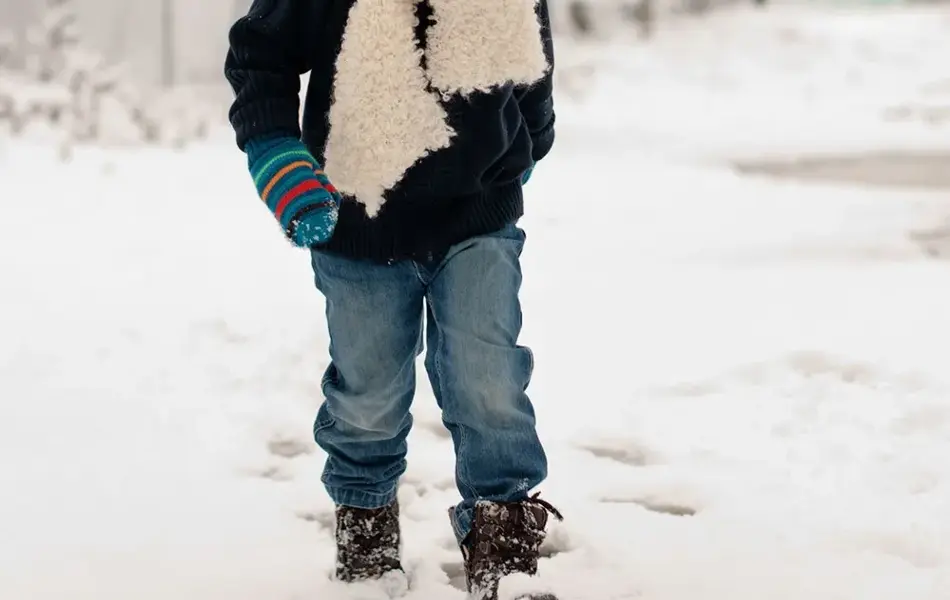 Liten gutt går på snø 