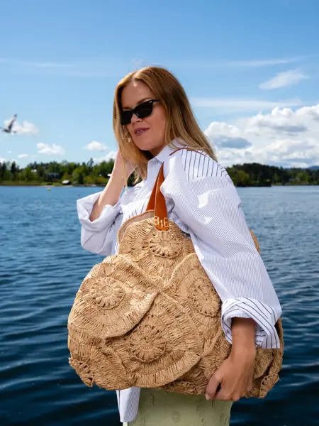 Elen i hvit skjorte med stor veske over skulderen