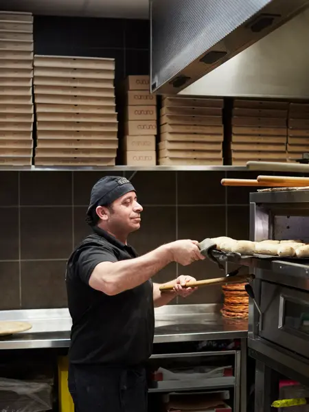 kokk som lager pizza hos grand caffe venezia