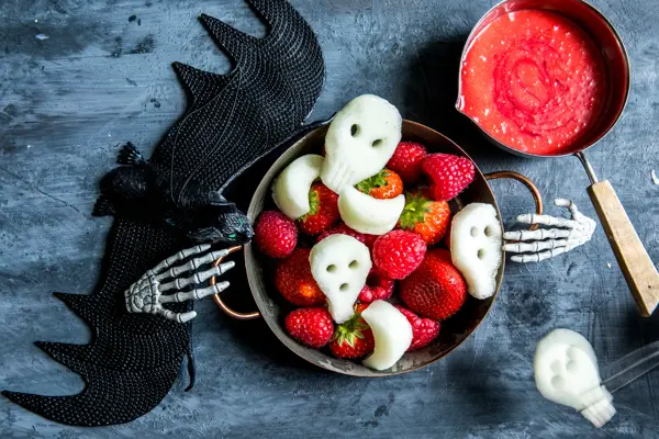 Fat med fruktfigurer som hodeskaller med halloweendekorasjon rundt