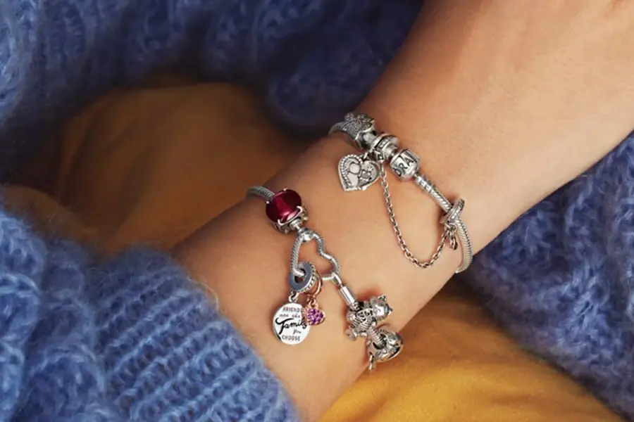 Person i blå strikket genser med smykker rundt håndleddet