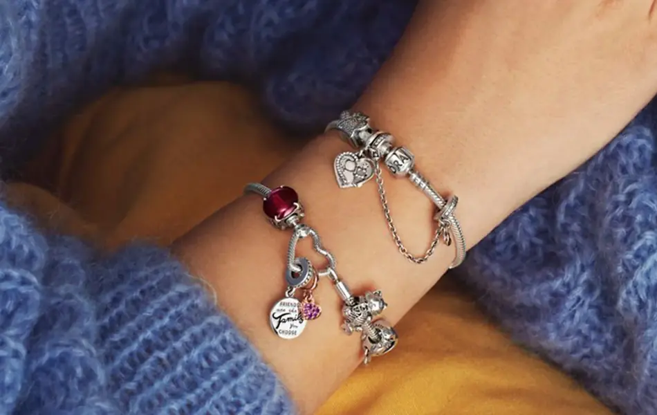 Person i blå strikket genser med smykker rundt håndleddet