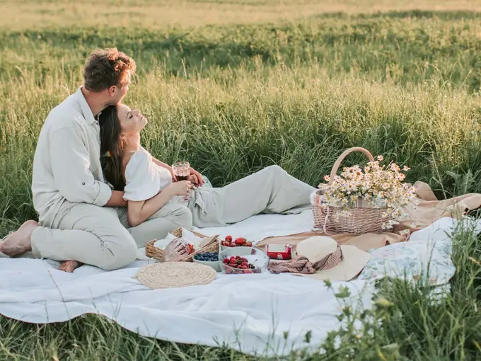 Dame og mann som har piknik i en eng