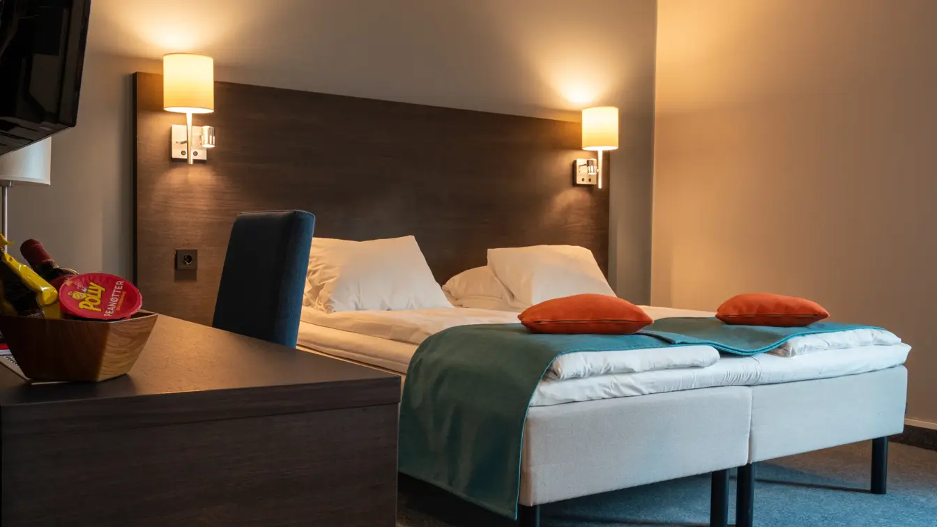 Dobbeltseng, skrivepult, TV, stol, lamper