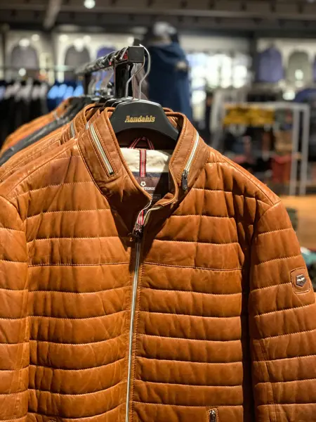 brun vinterjakke henger på stativ