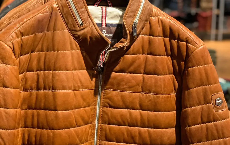 brun vinterjakke henger på stativ