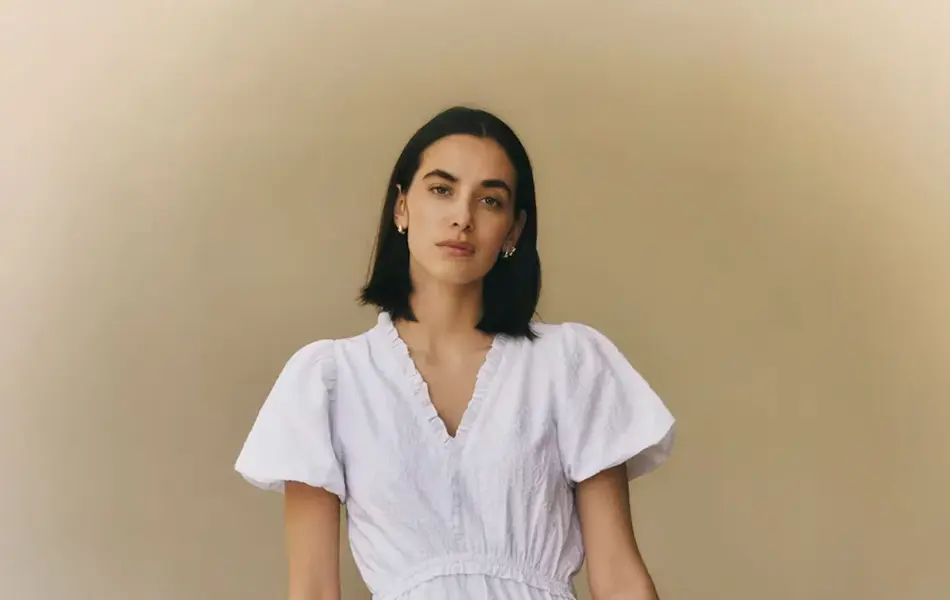 Dame som holder en blomsterbukett og har på seg en hvit kjole