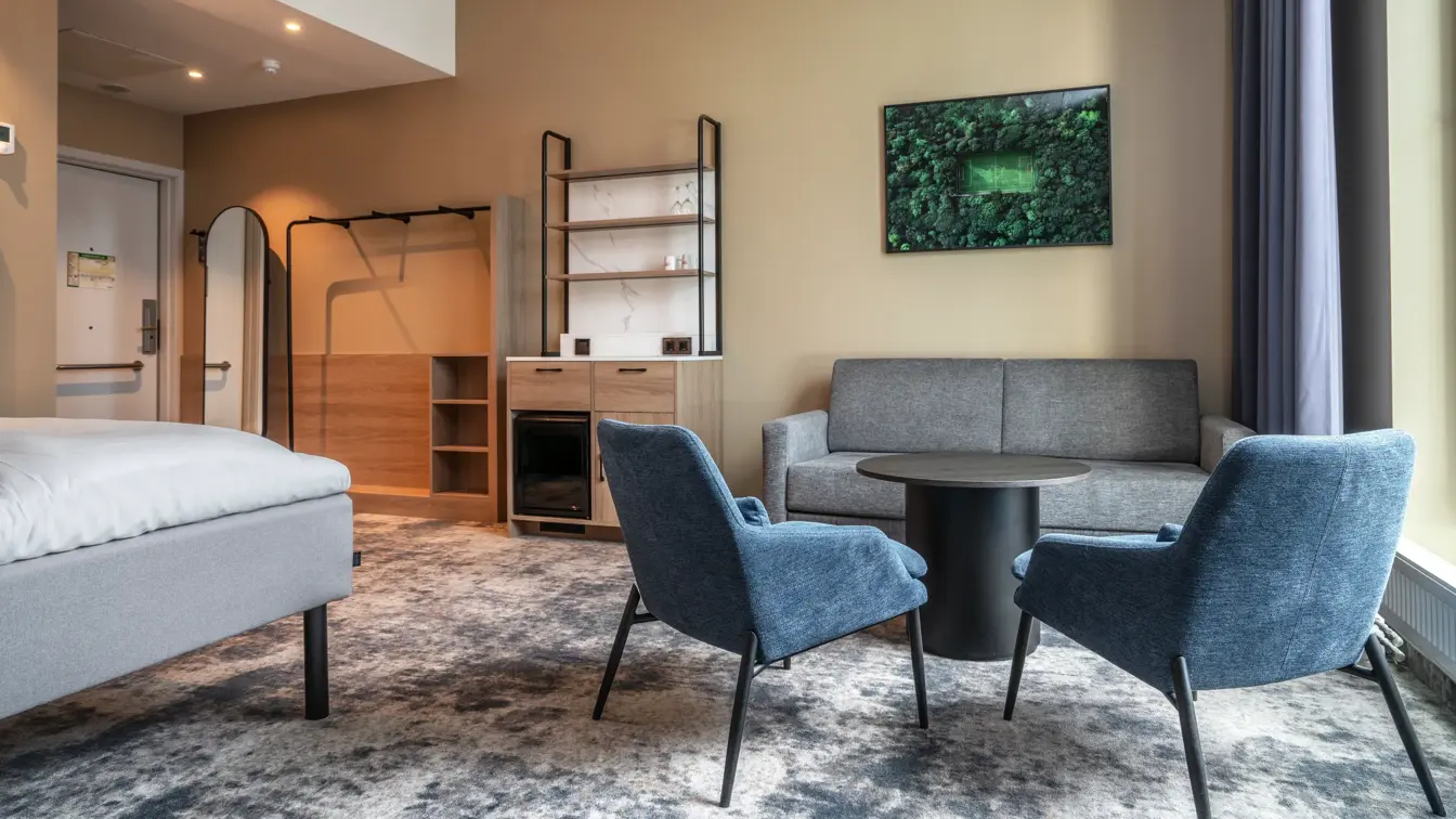 Handicapvennlig rom med sittegruppe, vegghengt TV, minibar, helspeil, åpent garderobestativ