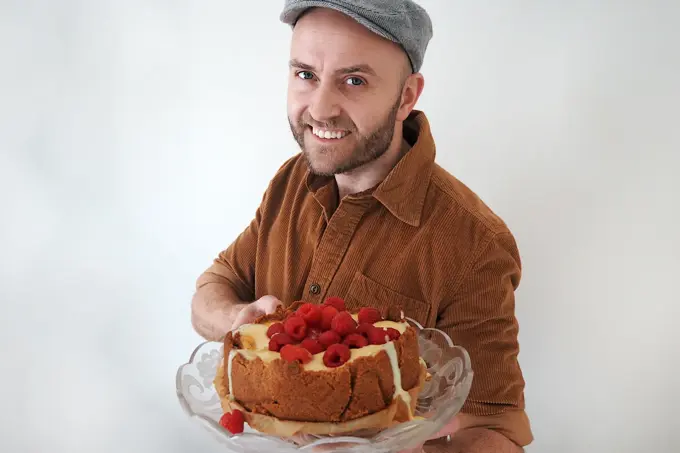 mann som holder fram den ferdige kaka