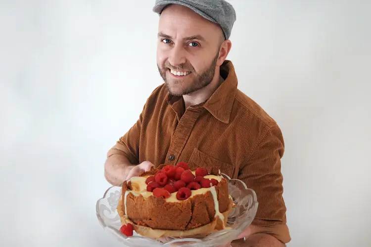 mann som holder fram den ferdige kaka