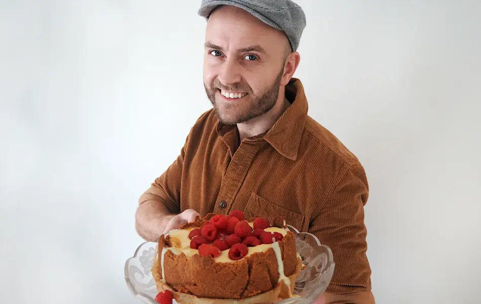 mann som holder fram den ferdige kaka