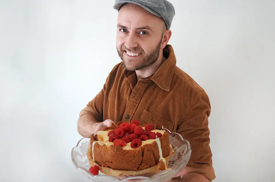 mann som holder fram den ferdige kaka