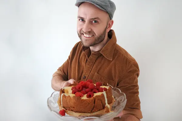 mann som holder fram den ferdige kaka