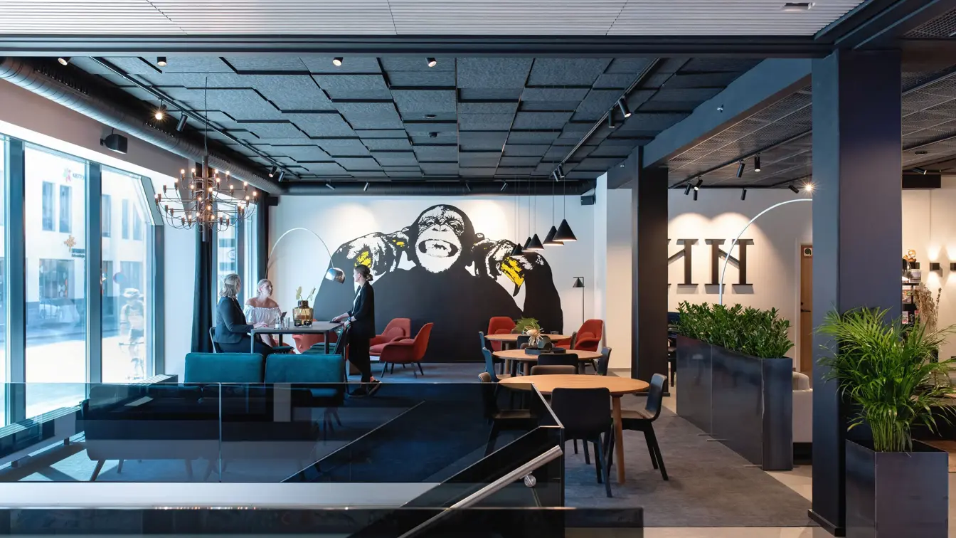 Store vinduer og vegg med en stor malt ape  i lobbyen på Thon Hotel Norge i Kristiansand.