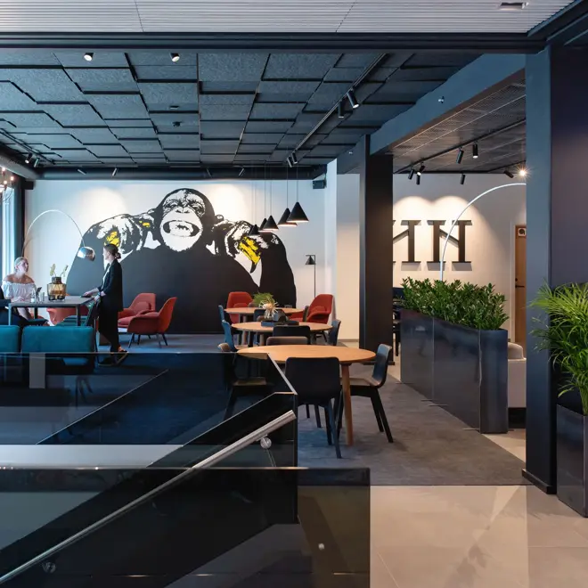 Store vinduer og vegg med en stor malt ape  i lobbyen på Thon Hotel Norge i Kristiansand.