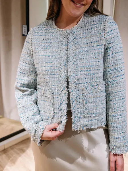 dame i vårklær står ved prøverom