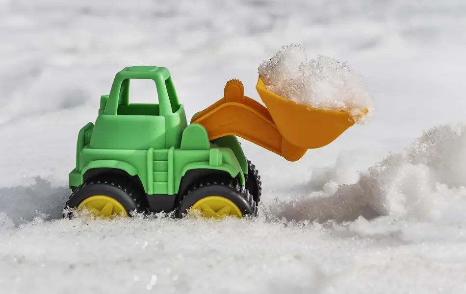 Leketraktor i snøen med skuffen full av snø