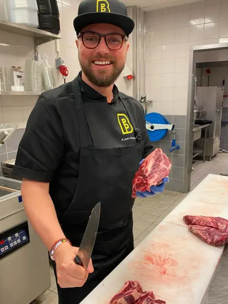 Mann med ferskt kjøtt i uniform fra Bunnpris & Gourmet på AMFI Alta