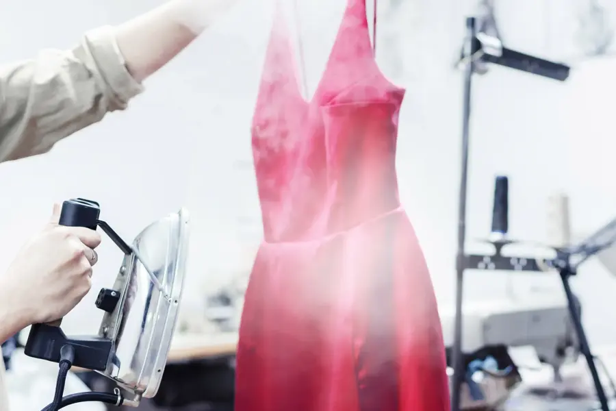 Noen som steamer en rosa kjole