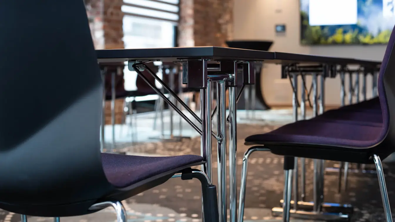Nærbilde av stoler og bord i et konferanserom