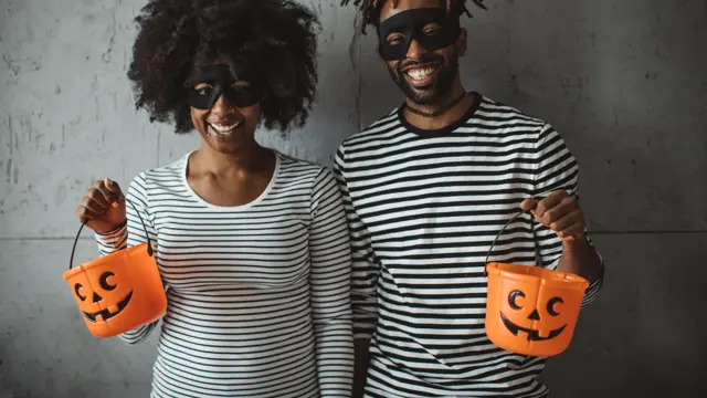 Young couple celebrating Halloween. They wear costumes, smiling and enjoy in holiday