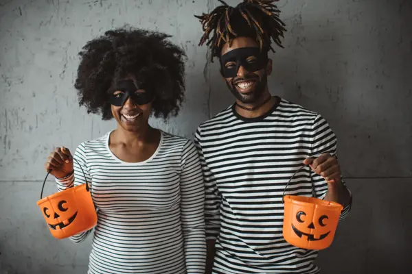Young couple celebrating Halloween. They wear costumes, smiling and enjoy in holiday