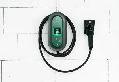 Ladekabel til el-bil henger på hvit vegg.